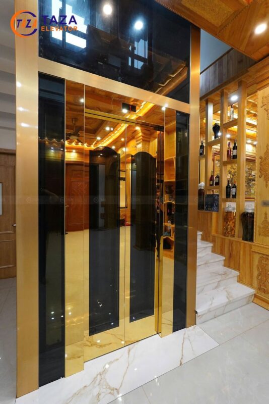 Bàn giao thang máy kính inox gương vàng cho biệt thự tân cổ điển