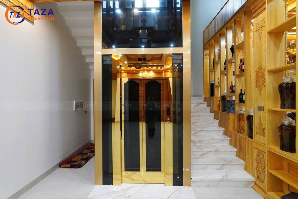Bàn giao thang máy kính inox gương vàng cho biệt thự tân cổ điển